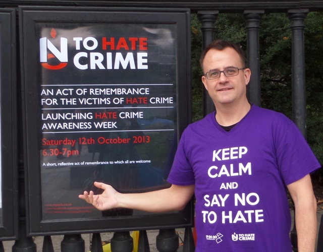 Mark Healey pointing to No To Hate Crime Poster displayed outside St Paul's Cathedral